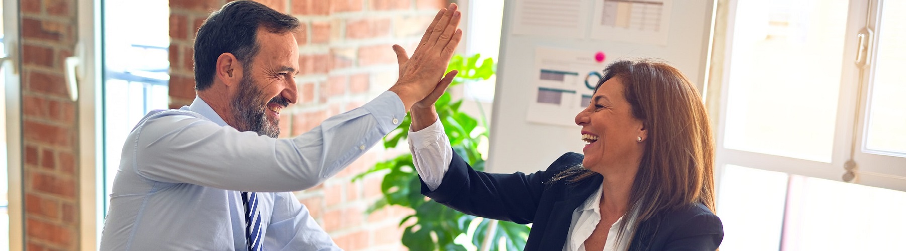 four people each holding a large puzzle piece towards each other